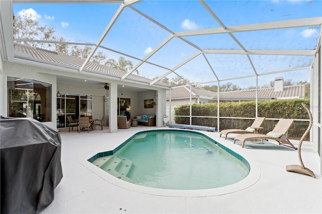 view of pool featuring a patio, an outdoor living space, glass enclosure, area for grilling, and ceiling fan