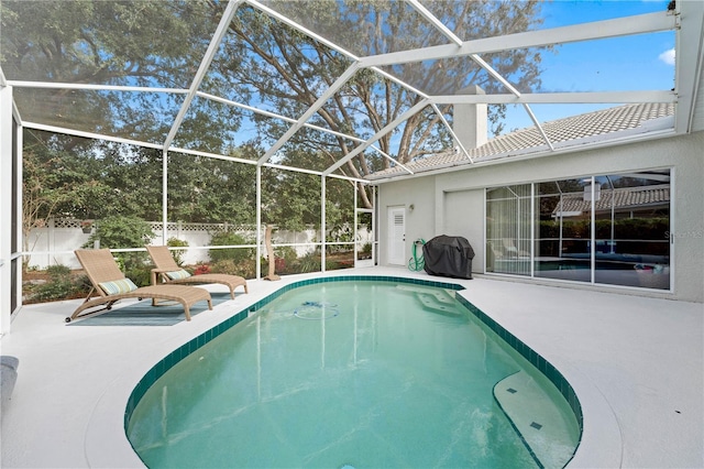 view of swimming pool featuring area for grilling, a patio, and glass enclosure