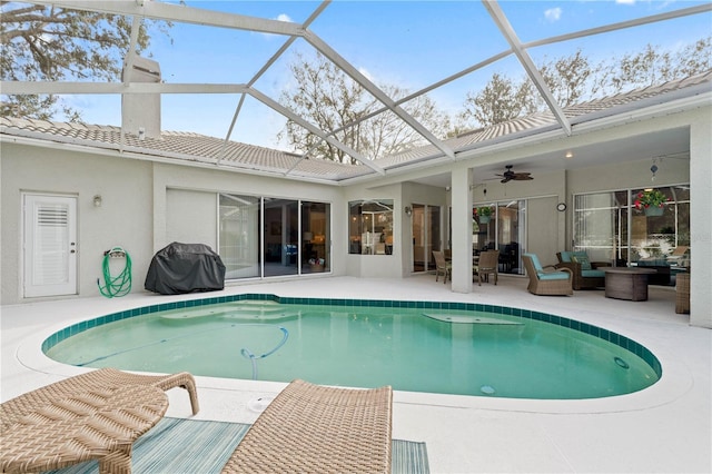 view of swimming pool featuring a patio, grilling area, ceiling fan, glass enclosure, and outdoor lounge area