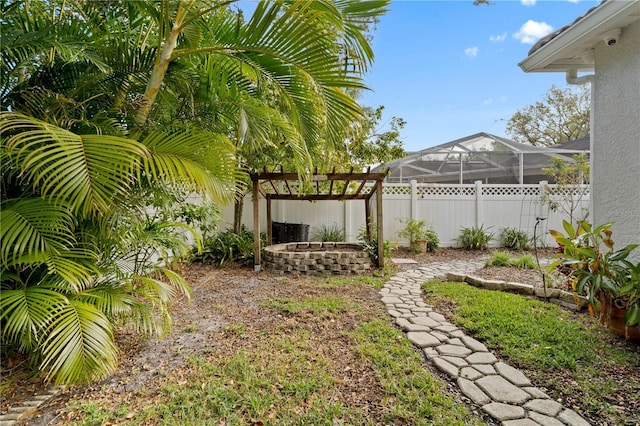 view of yard featuring a lanai, a pergola, and an outdoor fire pit