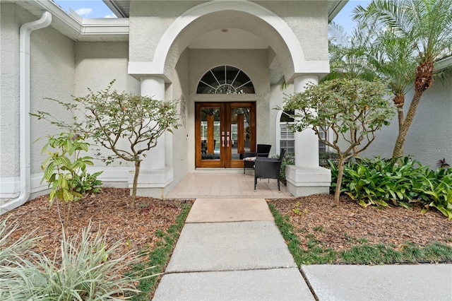 entrance to property with french doors and stucco siding