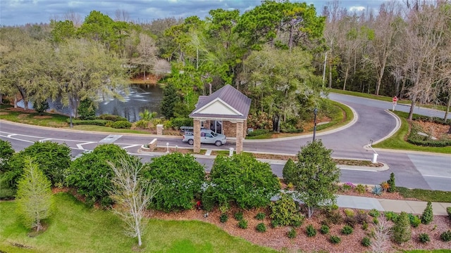 surrounding community with a water view and a view of trees