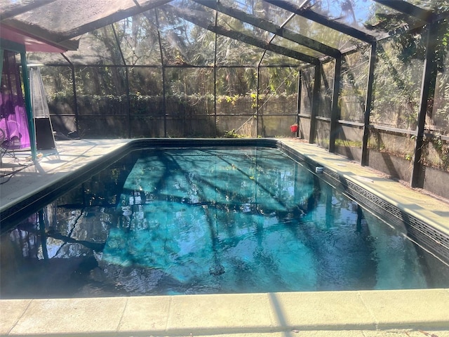 view of pool with a patio and glass enclosure