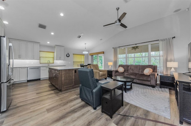 living room featuring sink, vaulted ceiling, light hardwood / wood-style floors, and ceiling fan