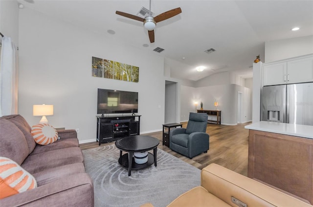 living room with ceiling fan, wood-type flooring, and vaulted ceiling