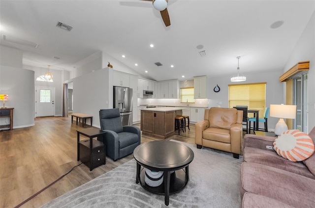 living room featuring ceiling fan, a healthy amount of sunlight, light hardwood / wood-style floors, and lofted ceiling