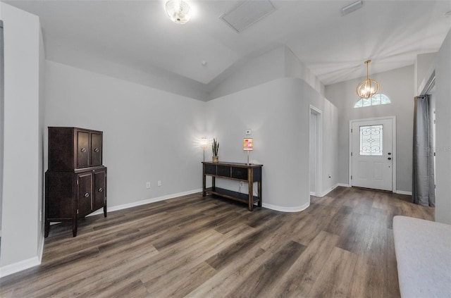 foyer featuring lofted ceiling, a notable chandelier, and dark hardwood / wood-style floors