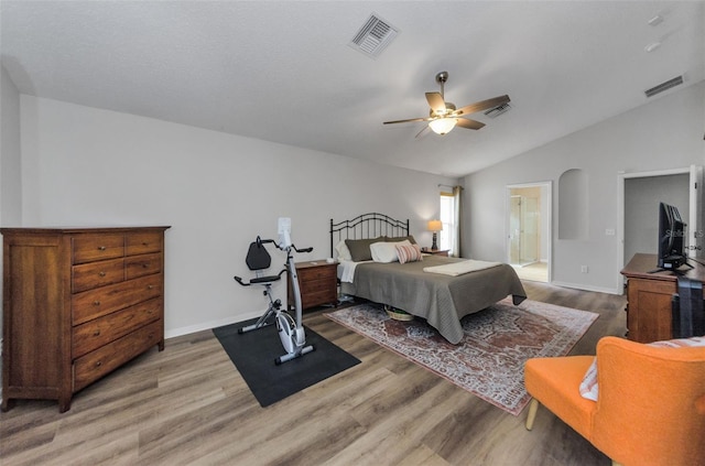 bedroom with hardwood / wood-style flooring, ensuite bathroom, lofted ceiling, and ceiling fan