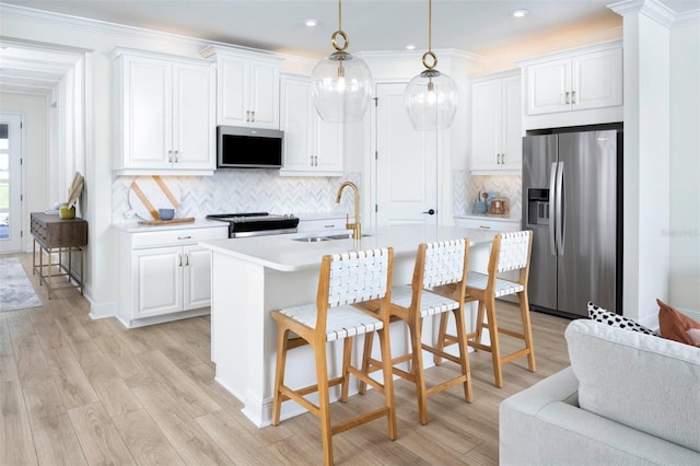 kitchen with decorative light fixtures, range, stainless steel refrigerator with ice dispenser, white cabinets, and sink