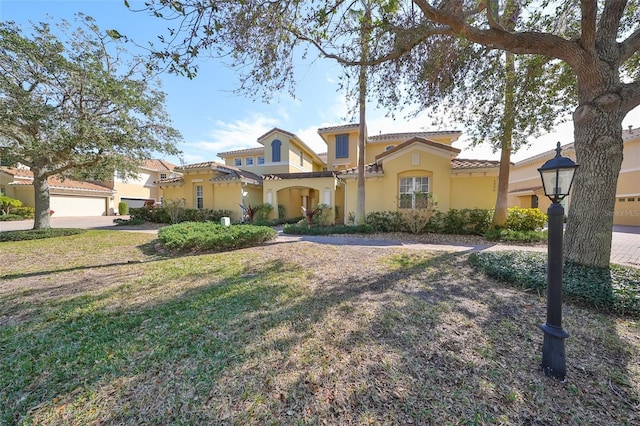 mediterranean / spanish-style house featuring a front lawn and a garage