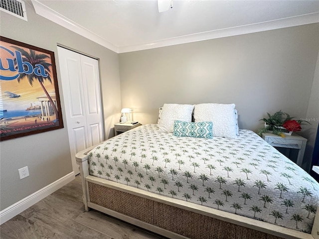 bedroom with ceiling fan, hardwood / wood-style floors, a closet, and crown molding