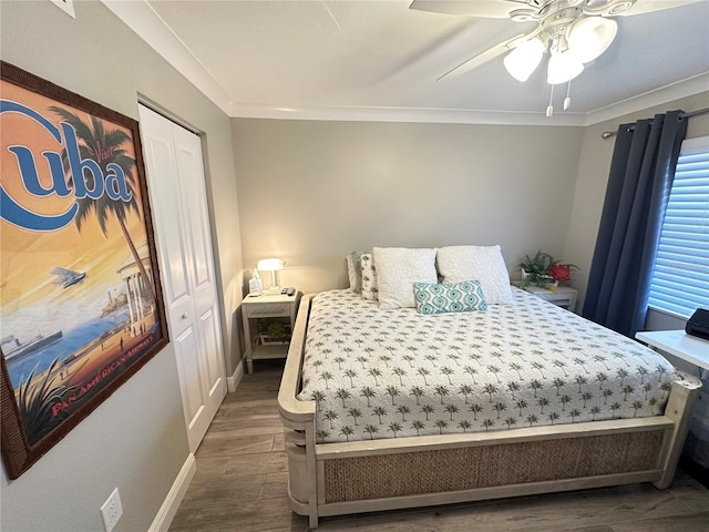 bedroom with ceiling fan, dark wood-type flooring, a closet, and crown molding