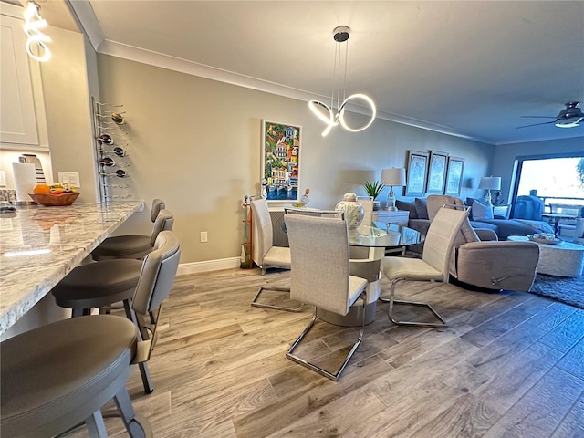 dining room featuring ceiling fan with notable chandelier, crown molding, and light hardwood / wood-style floors