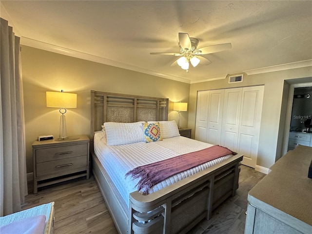 bedroom featuring ceiling fan, dark hardwood / wood-style floors, a closet, and ornamental molding