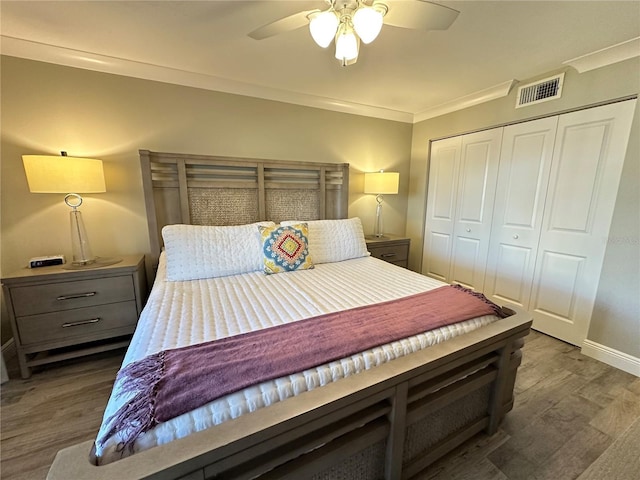 bedroom featuring ceiling fan, a closet, crown molding, and hardwood / wood-style flooring