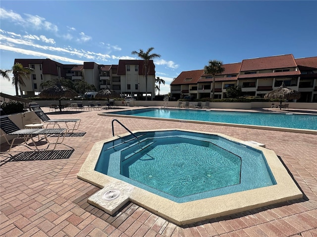 view of swimming pool featuring a hot tub and a patio