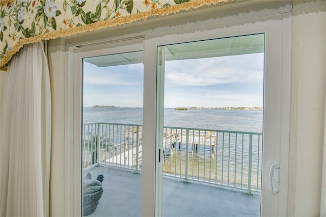 doorway to outside with carpet floors and a water view