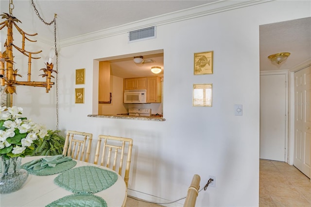 dining area featuring ornamental molding and light tile patterned flooring