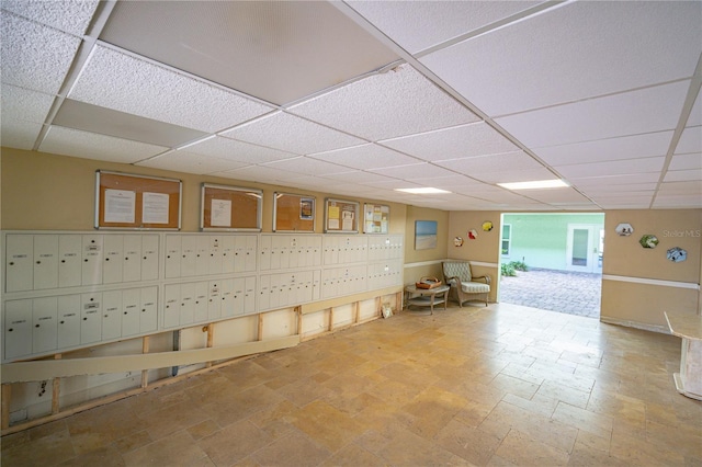 basement featuring a mail area and a paneled ceiling