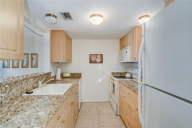 kitchen with light stone countertops, white appliances, light brown cabinetry, sink, and light tile patterned floors