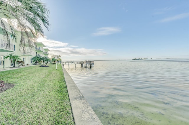 dock area with a water view and a lawn