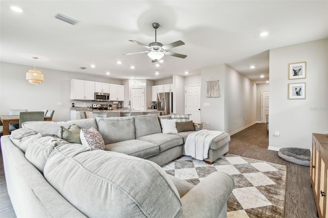 living room featuring ceiling fan, light hardwood / wood-style flooring, and sink