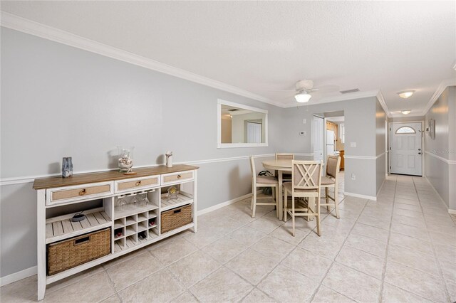 tiled dining area featuring ceiling fan and ornamental molding