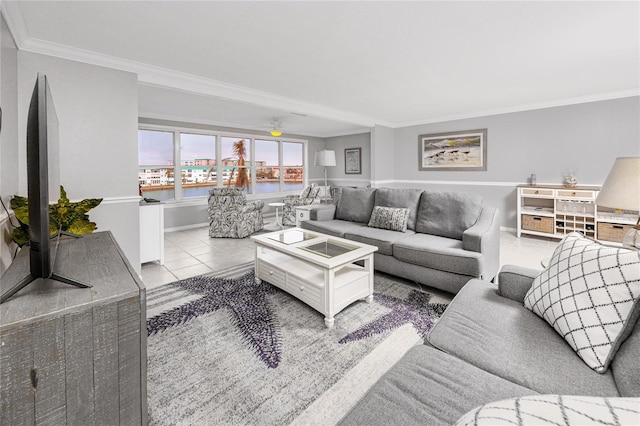 tiled living room featuring ceiling fan, crown molding, and a water view