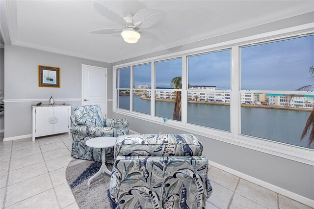 sunroom / solarium featuring ceiling fan and a water view