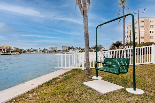 view of dock with a water view and a lawn