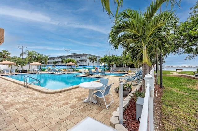 view of swimming pool with a water view and a patio