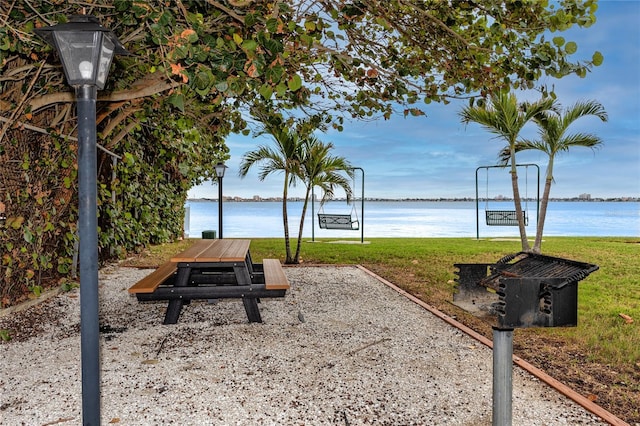 view of property's community with a water view and a yard