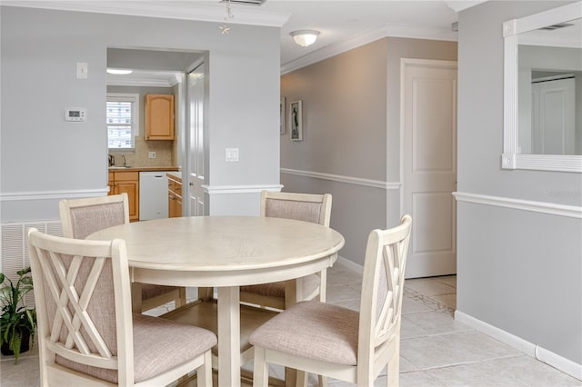 tiled dining room featuring sink and ornamental molding