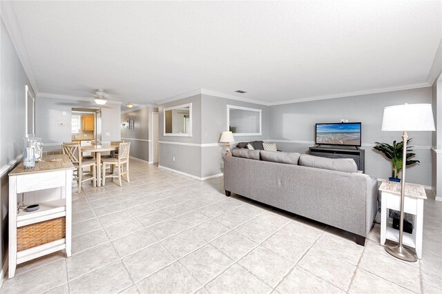 tiled living room with ornamental molding and ceiling fan