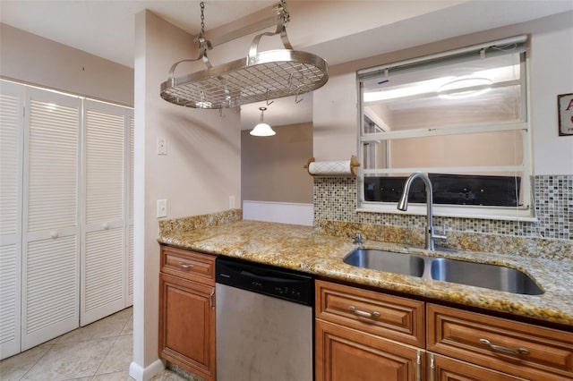 kitchen featuring sink, stainless steel dishwasher, tasteful backsplash, and hanging light fixtures