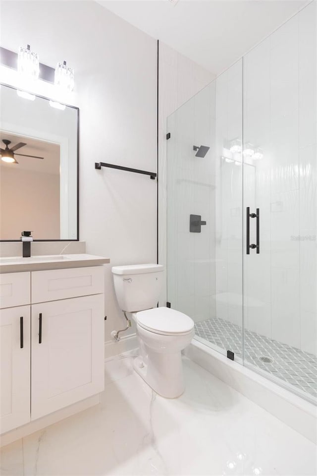 bathroom with ceiling fan, walk in shower, vanity, and toilet