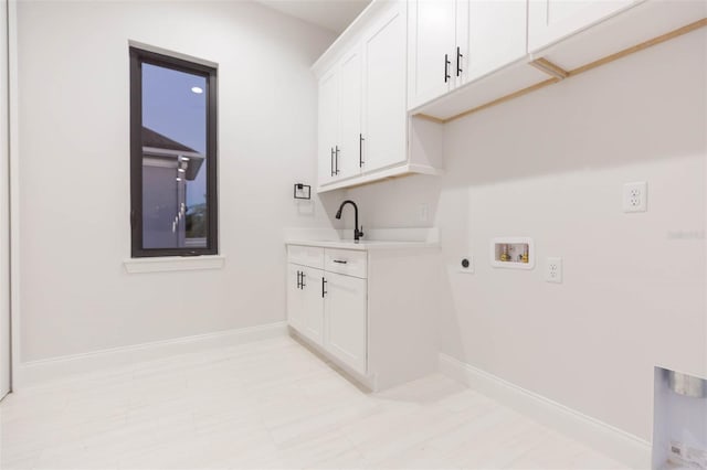 laundry room featuring electric dryer hookup, hookup for a washing machine, and cabinets