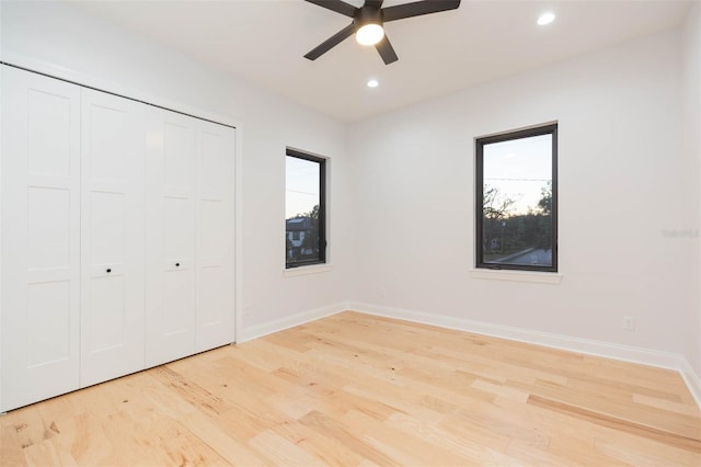 unfurnished bedroom featuring ceiling fan, light hardwood / wood-style flooring, and a closet