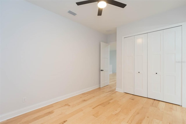 unfurnished bedroom featuring ceiling fan, light hardwood / wood-style flooring, and a closet