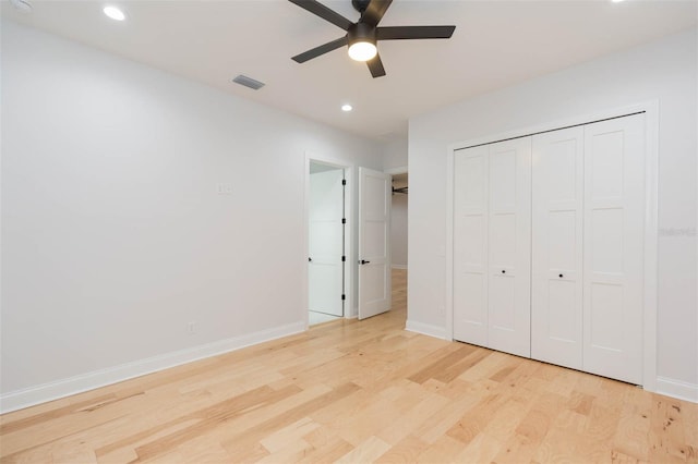 unfurnished bedroom with ceiling fan, light wood-type flooring, and a closet