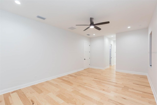 empty room with ceiling fan and light hardwood / wood-style floors