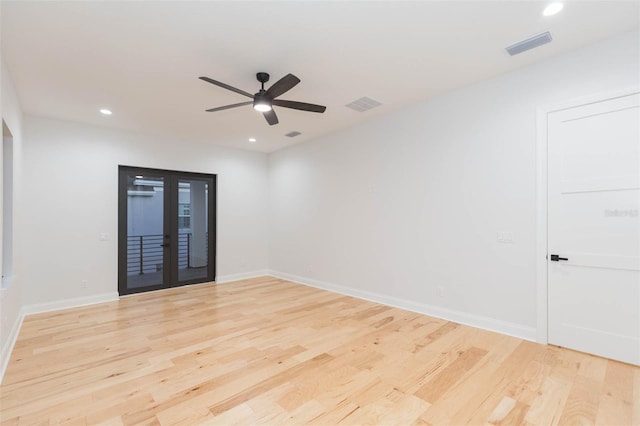 empty room featuring ceiling fan, light wood-type flooring, and french doors