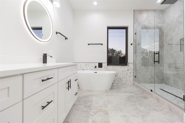 bathroom with vanity, tile walls, and plus walk in shower