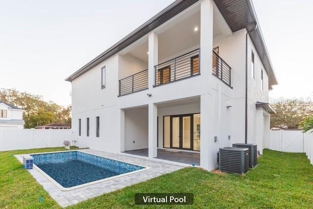 rear view of house featuring a balcony, a patio, a lawn, a fenced in pool, and central AC unit