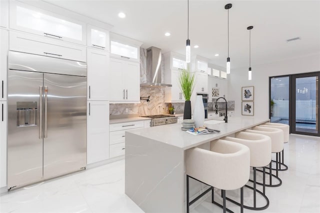 716 S Lois Ave, Tampa, FL 33609 - kitchen featuring stainless steel built in fridge, wall chimney range hood, decorative backsplash, white cabinetry, and recessed lighting