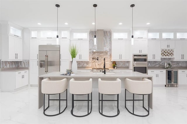 716 S Lois Ave, Tampa, FL 33609 - kitchen featuring wall chimney exhaust hood, stainless steel appliances, wine cooler, backsplash, and light marble finish flooring