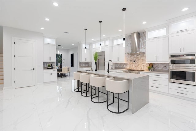 716 S Lois Ave, Tampa, FL 33609 - kitchen featuring wall chimney exhaust hood, stainless steel appliances, tasteful backsplash, recessed lighting, and a kitchen bar