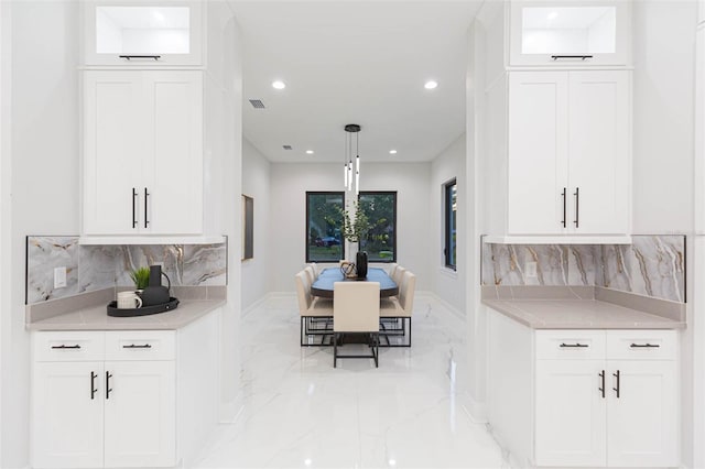 716 S Lois Ave, Tampa, FL 33609 - kitchen with light marble finish floors, backsplash, recessed lighting, and glass insert cabinets