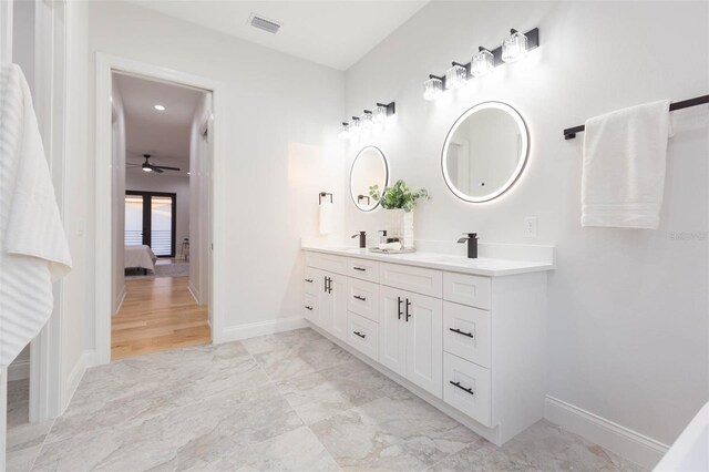 716 S Lois Ave, Tampa, FL 33609 - ensuite bathroom with double vanity, baseboards, a ceiling fan, and marble finish floors