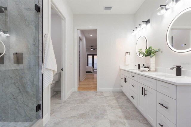 716 S Lois Ave, Tampa, FL 33609 - ensuite bathroom featuring a stall shower, double vanity, toilet, marble finish flooring, and a ceiling fan